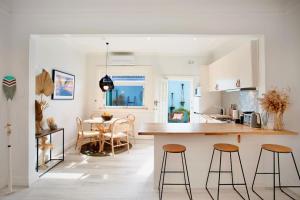 a kitchen and dining room with a table and stools at Bondi Surf Cottage in Sydney