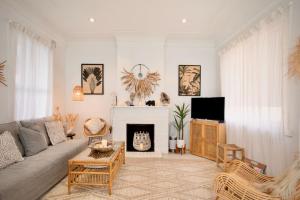 a living room with a couch and a fireplace at Bondi Surf Cottage in Sydney