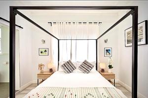 a bedroom with a black canopy bed with pillows at Bondi Surf Cottage in Sydney +50 photos