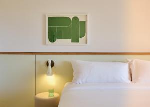a bedroom with a white bed and a lamp at The Roy in Rainbow Beach +2 photos