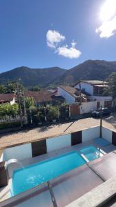 a swimming pool in front of a house at Pousada Tribo Ubatuba in Ubatuba