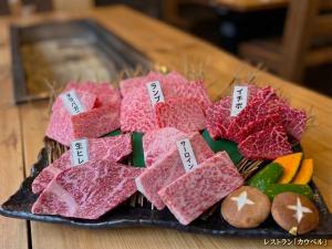 a plate of meat and vegetables on a table at Prirate Villa Naru in Shiraoi