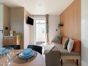a living room with a table and a couch at New Vennepark caravan 463 6p in De Haan