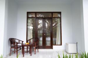 a patio with a table and chairs and a door at Ayu Shanti Guest House Ubud in Ubud