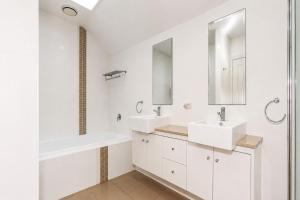 a white bathroom with two sinks and a mirror at Mariners Mark 1 in Hawks Nest +19 photos