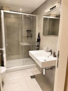 a bathroom with a white sink and a shower at FONTANA DELUXE Apartment in Budva +6 photos