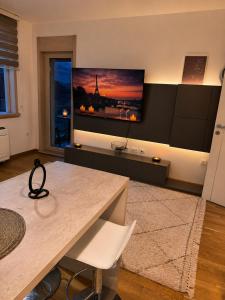 a living room with a table and a tv on the wall at FONTANA DELUXE Apartment in Budva