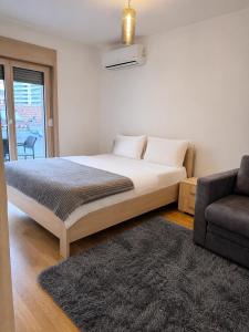 a bedroom with a large bed and a couch at FONTANA DELUXE Apartment in Budva