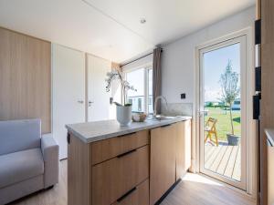 a kitchen with a counter and a large window at Caravan Bredene by the sea in Bredene