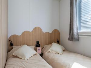 two beds sitting next to each other in a bedroom at Caravan Bredene by the sea in Bredene