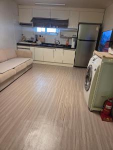 a living room with a couch and a kitchen at Moomoo House in Busan +8 photos