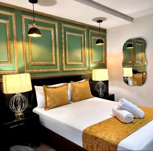 a bedroom with a large white bed with two lamps at Hotel Plaza Garibaldi in Caldas