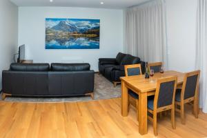 a living room with a black couch and a table at Whakatā in Te Anau