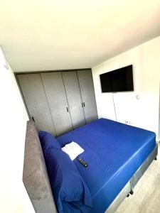 a bedroom with a blue bed with cabinets and a television at Apartamento modero nuevo, 3 habitaciones y parqueadero en conjunto in Neiva