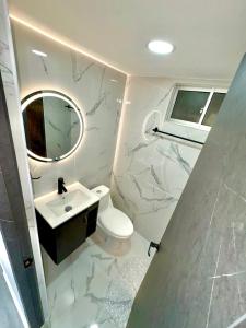 a bathroom with a toilet and a sink and a mirror at Apartamento modero nuevo, 3 habitaciones y parqueadero en conjunto in Neiva +9 photos