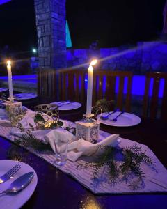 a table with white plates and candles on it at TUBURAN Poolside in Nagsulang
