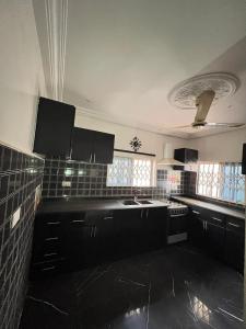 a kitchen with black cabinets and a sink at Mavis Lodge in Janman