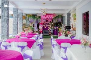 a room with pink and white tables and chairs at TUBURAN Poolside in Nagsulang