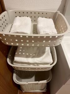 a white laundry basket with white towels in a drawer at Arch Garden in Ishihara +18 photos