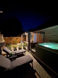 a patio with a jacuzzi tub at night at Dalmatian Stone House Angela in Drniš