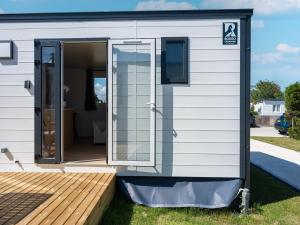 a tiny house with a large glass door at Caravan Bredene on the coast in Bredene +31 photos