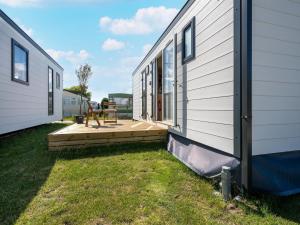 a backyard with a deck next to a house at Caravan Bredene on the coast in Bredene