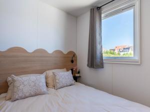 a bedroom with a bed with a large window at Caravan Bredene on the coast in Bredene