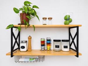 a shelf with pots and pans and a plant at Casa da Prainha - a 3min da areia - aproveite até o pôr do sol! in Arraial do Cabo