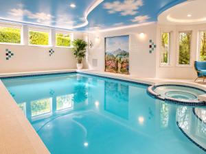 a pool in a house with blue water and windows at Van Nest near YVR UBC Downtown Free Parking in Vancouver