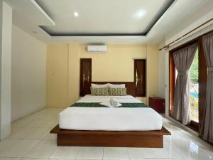 a bedroom with a large white bed in a room at Melati resort kuta lombok in Kuta Lombok