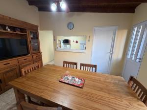 a dining room with a wooden table and a television at Refugio serrano in Tandil