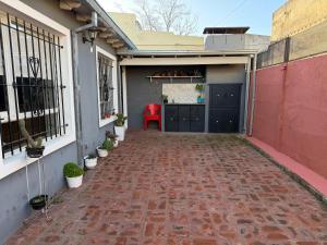 a garage with a red chair on a brick driveway at Refugio serrano in Tandil