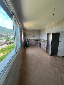a large kitchen with a refrigerator and a large window at La Vista Azul in Belyounech 