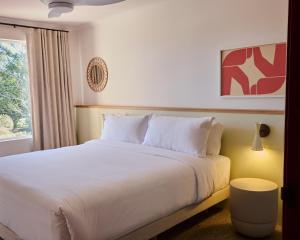 a bedroom with a large white bed with a window at The Roy in Rainbow Beach