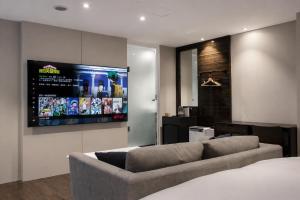 a living room with a couch and a flat screen tv at P&F Hotel in Taichung