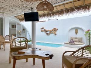a living room with a table and chairs and a tv at Villa Sei Uluwatu by LODGELINK BALI in Uluwatu