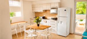 a kitchen with a table and a refrigerator at Playa Azul Exclusive Suites in Tonsupa