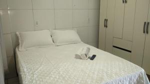 a white bed with a phone on top of it at Apartamento aconchegante in Marabá