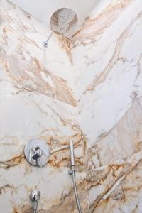 a shower in a bathroom with a marble wall at Villa St George in Kalymnos +25 photos