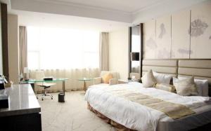 a large bedroom with a large bed and a desk at Huai'an Jinling Hotel in Huai'an