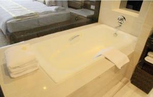 a bathroom with a bath tub with a sink at Huai'an Jinling Hotel in Huai'an