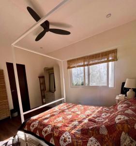 a bedroom with a bed and a ceiling fan at Villa Patria in Calatagan