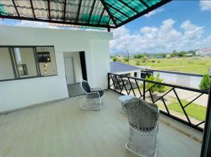 a balcony with two chairs and a view of a field at Villa renacer 1 in Baní
