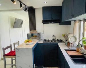 a kitchen with black cabinets and a bowl of fruit on the counter at Villa renacer 1 in Baní