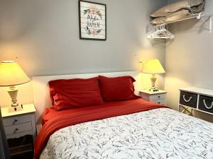 a bedroom with a red and white bed and two lamps at Barker house-Sweet home in Niagara-on-the-Lake