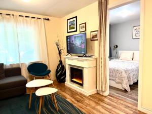 a bedroom with a bed and a fireplace with a television at Barker house-Sweet home in Niagara-on-the-Lake