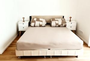 a bedroom with a large white bed with two night stands at Luxus Lakópark in Gárdony +7 photos