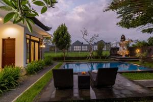 a pool in a backyard with chairs and a table at Ayu Shanti Guest House Ubud in Ubud +37 photos