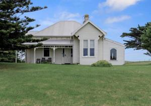 a white house with a grassy yard at Cork Hill Retreat in Cape Bridgewater