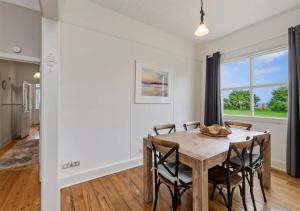 a dining room with a wooden table and chairs at Cork Hill Retreat in Cape Bridgewater +11 photos